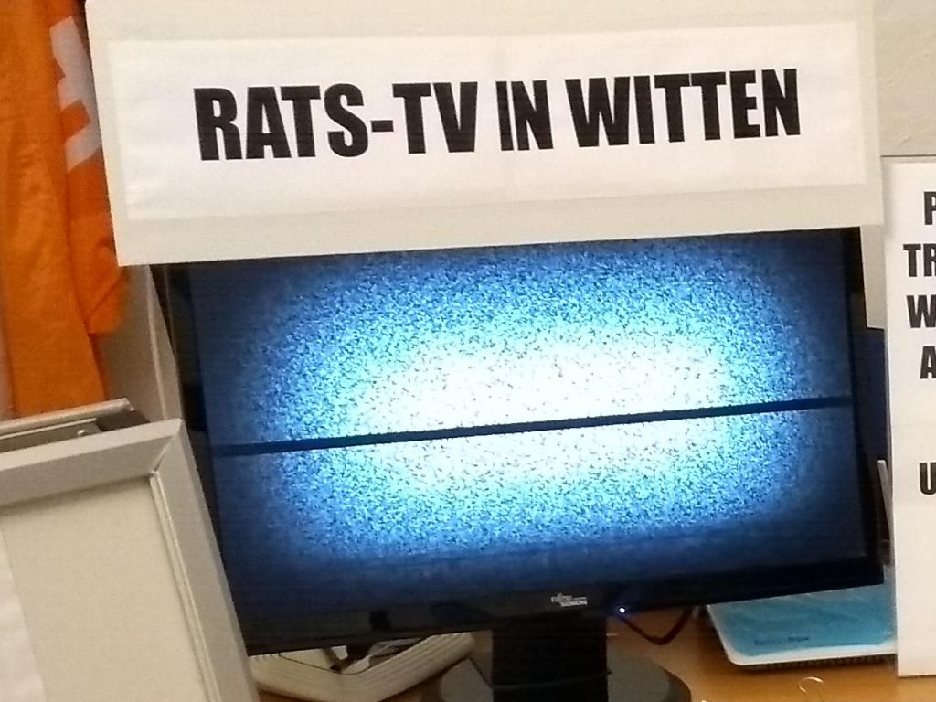 Monitor mit weißem Rauschen auf dem Bildschirm. Darüber eine Beschriftung „Rats-TV in Witten“