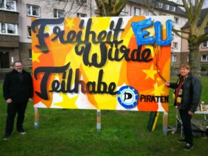Roland Löpke und Stefan Borggraefe vor dem Streetart-Wahlplakat der Piraten zur Europawahl