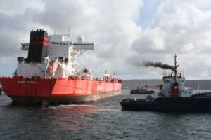 Ein Schlepper zieht einen Tanker